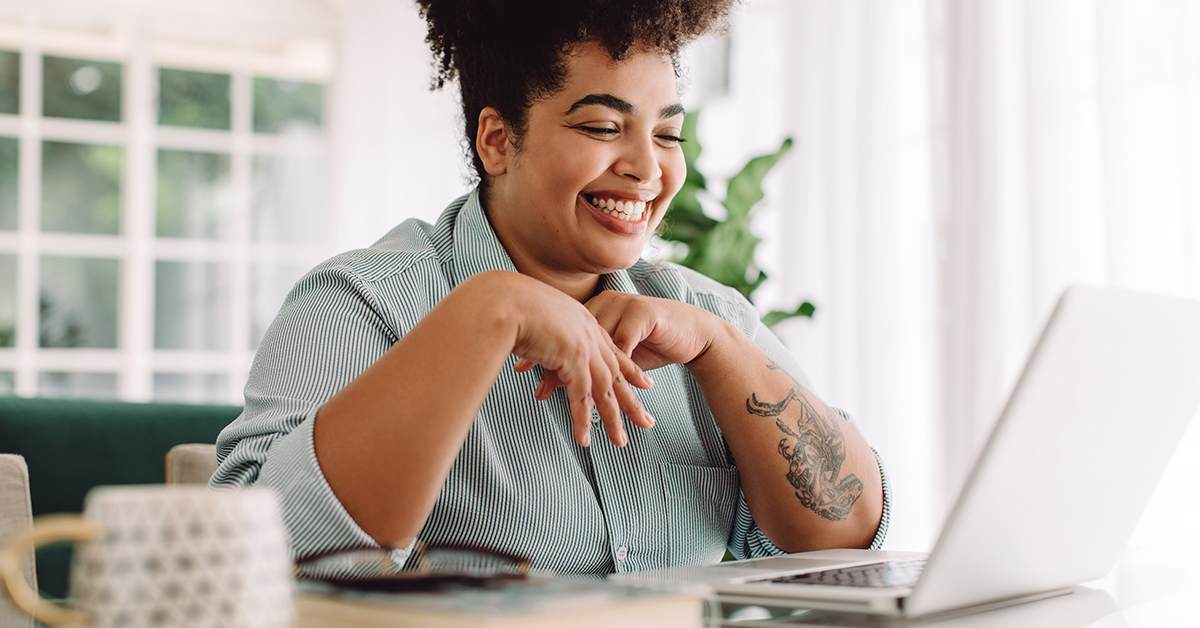 A person on a laptop looking happy about their investments