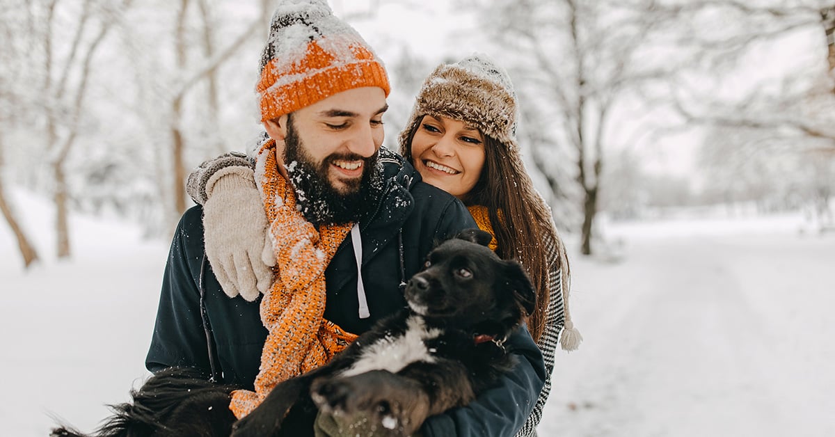 Young couple with dog outside in winter